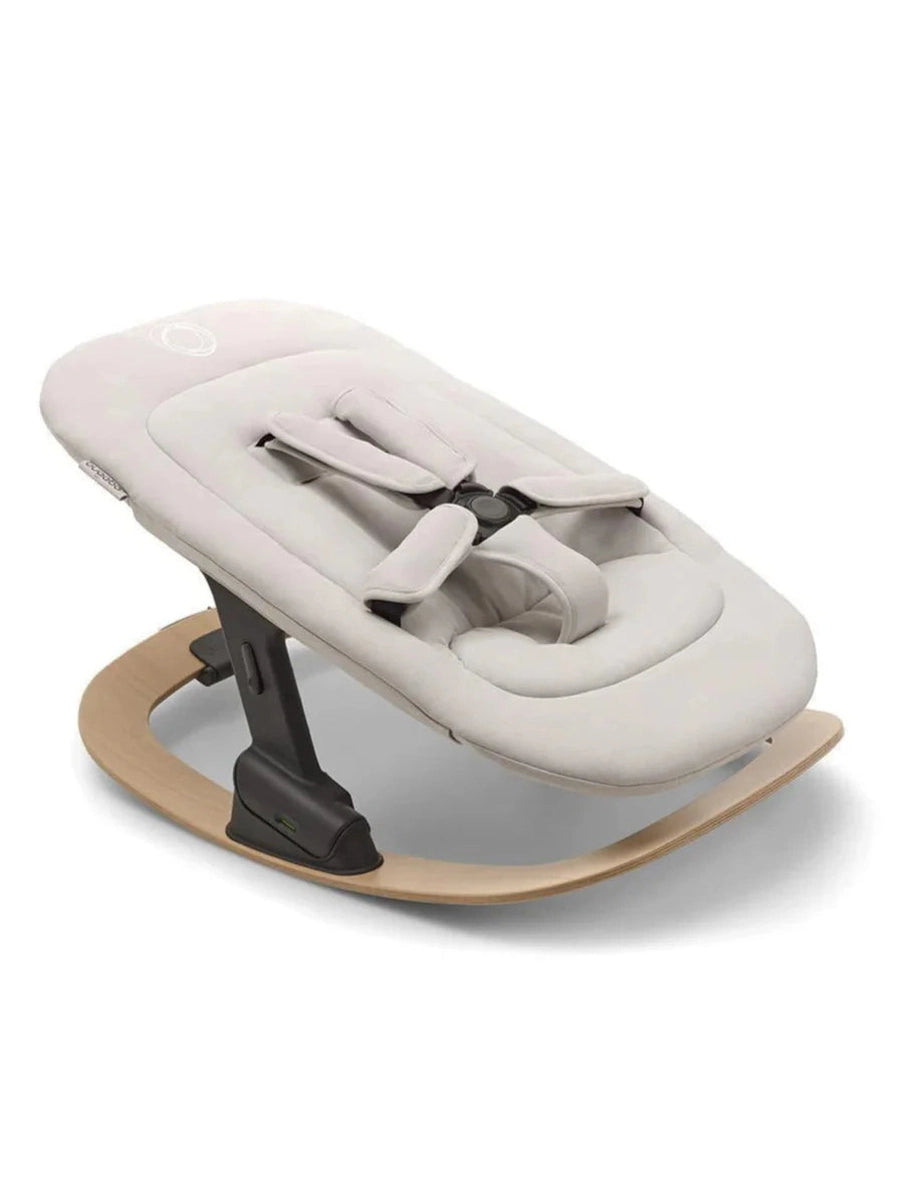 Baby rocker with beige cushion and wooden base on a white background